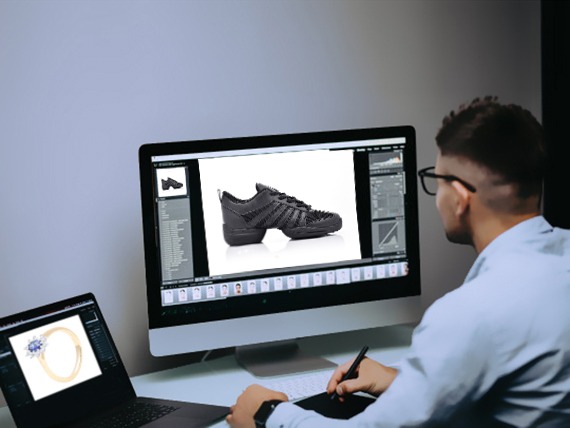 A man editing shoe picture in a desktop and laptop